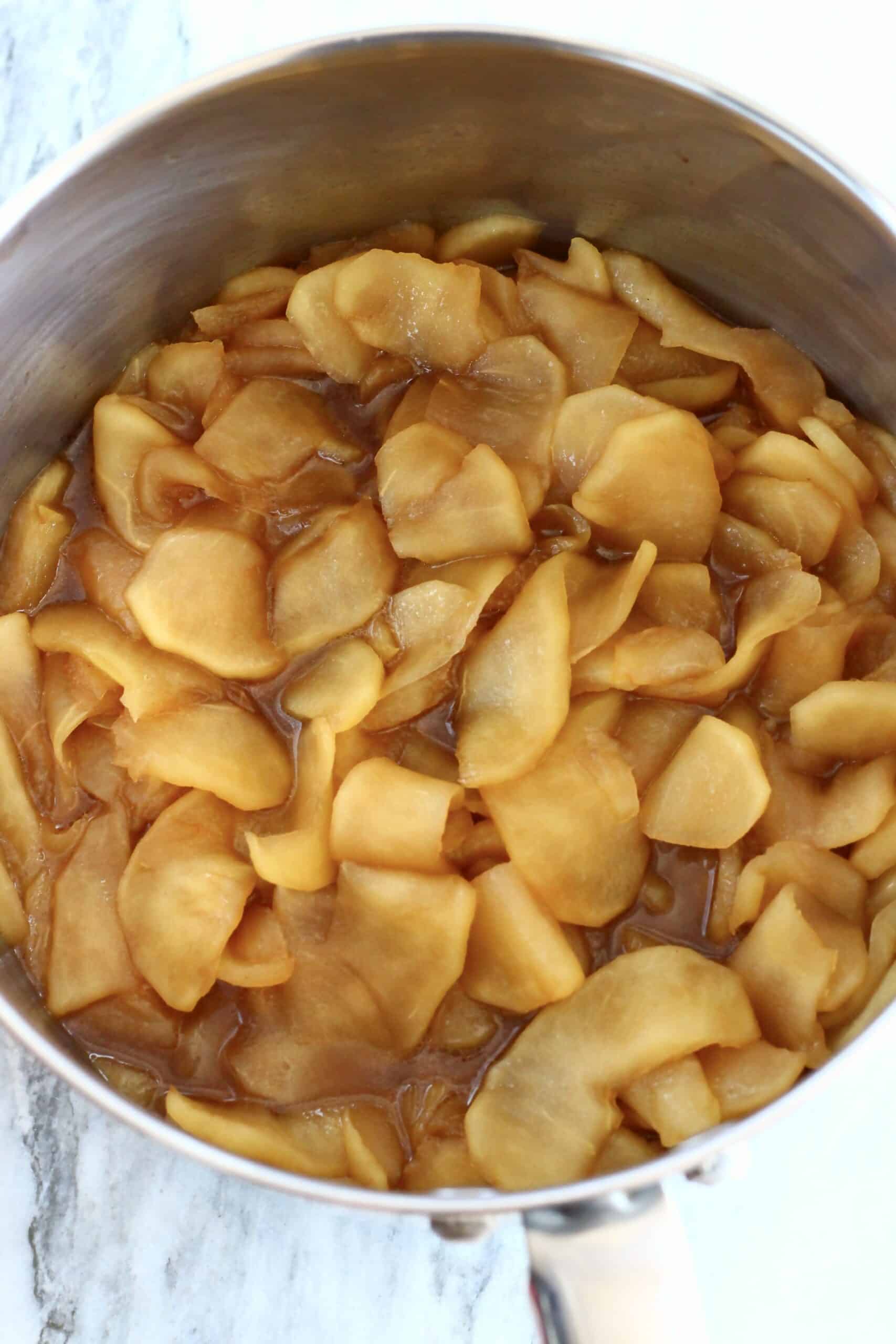 Cooked sliced apples with coconut sugar and cinnamon in a saucepan