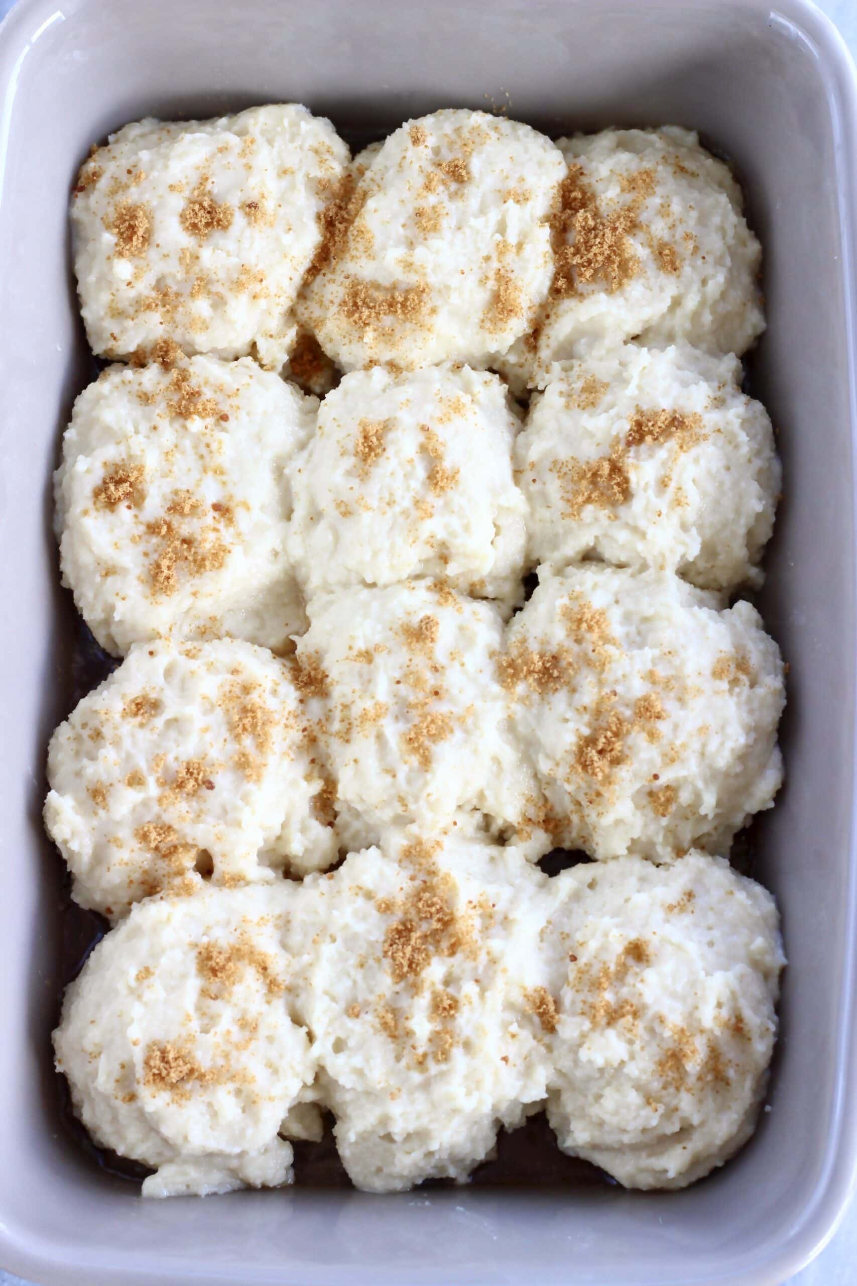 Raw gluten-free vegan apple cobbler sprinkled with coconut sugar in a baking dish
