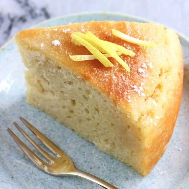 A slice of vegan lemon olive oil yogurt cake on a plate with a fork