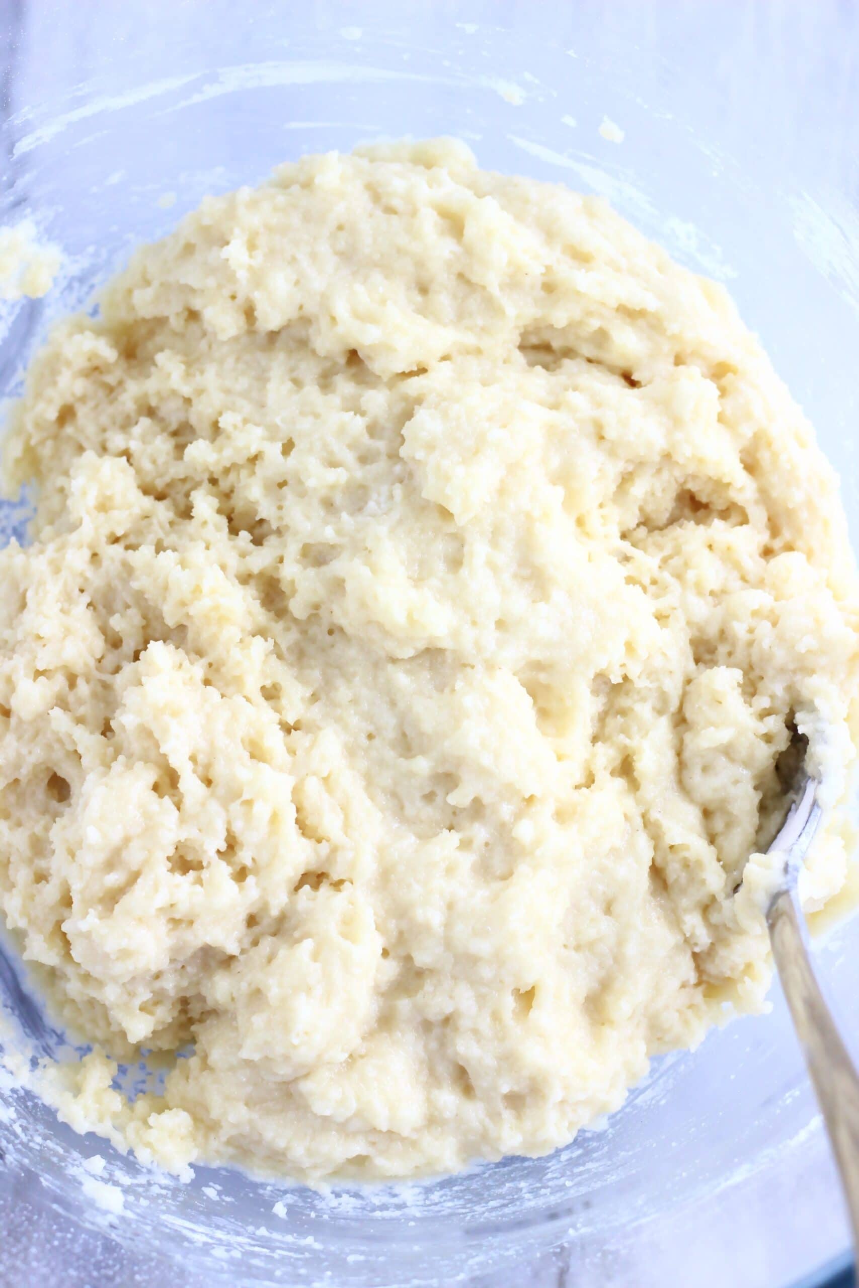 Raw dough for vegan lemon cobbler in a mixing bowl with a spoon