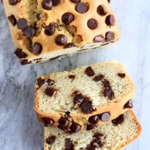 A loaf of gluten-free vegan chocolate chip bread with two slices next to it