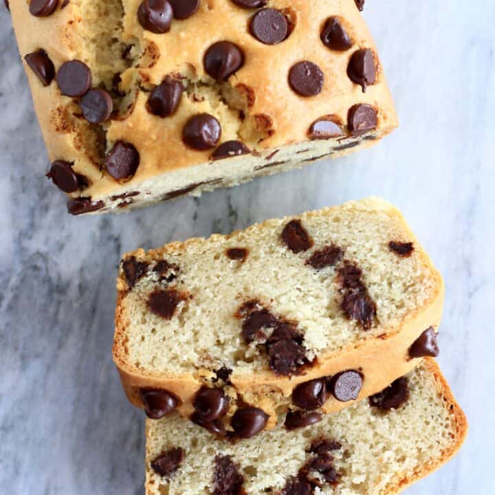 A loaf of gluten-free vegan chocolate chip bread with two slices next to it