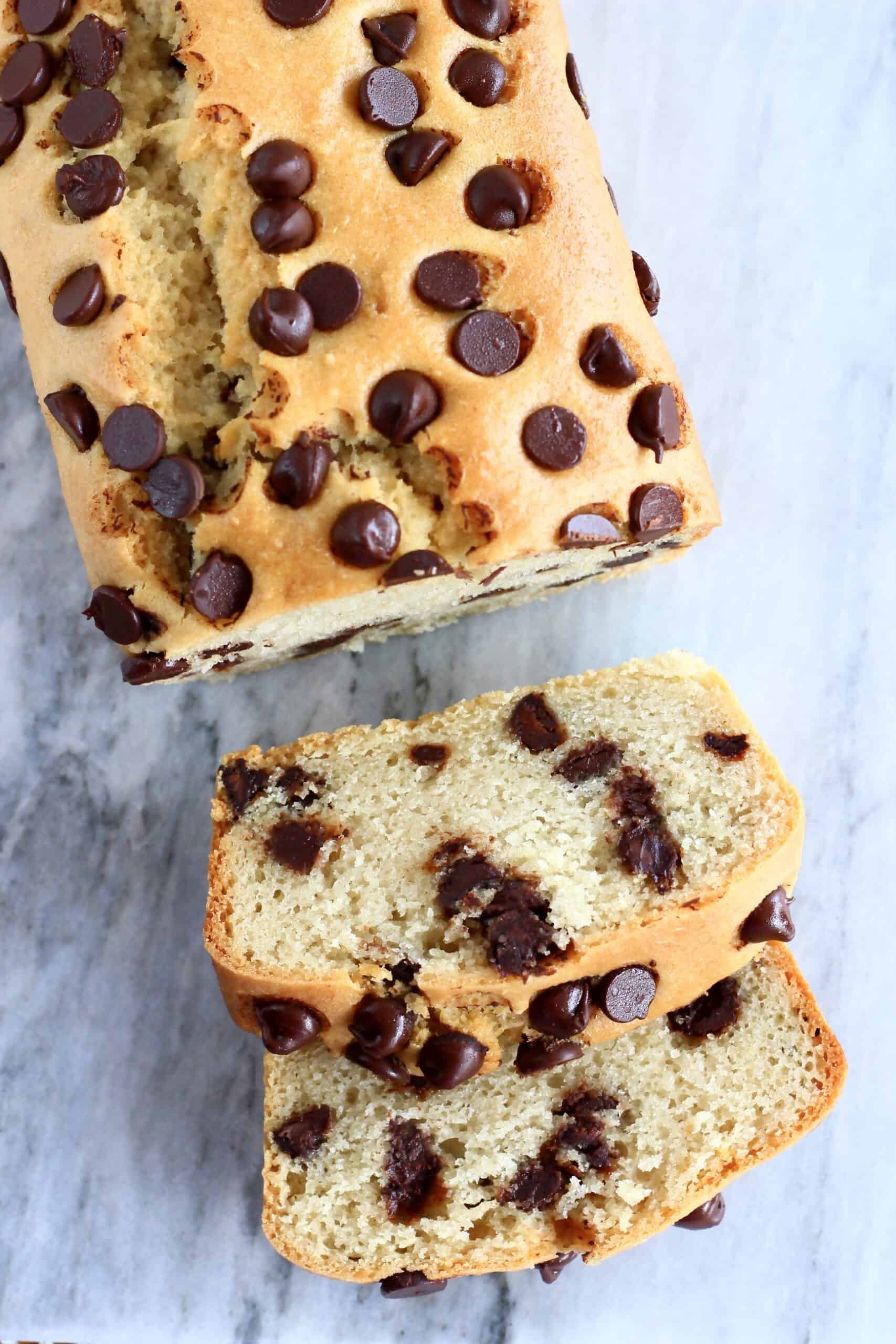 A loaf of gluten-free vegan chocolate chip bread with two slices next to it