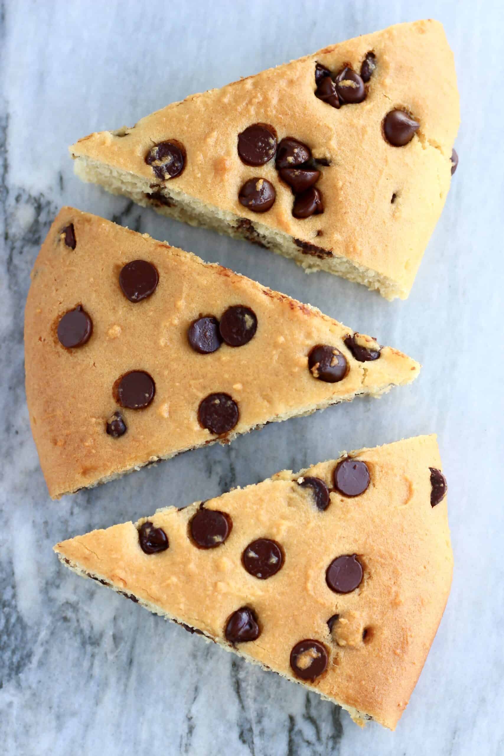 Three gluten-free vegan chocolate chip scones on a marble background