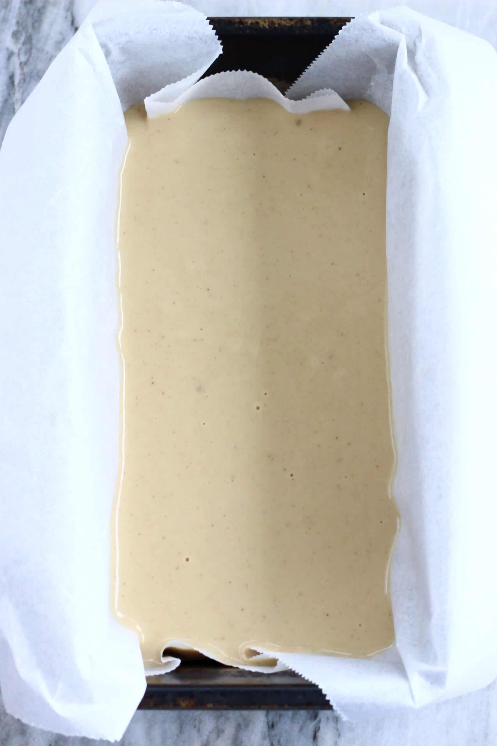 Raw vegan butter mochi batter in a loaf tin lined with baking paper