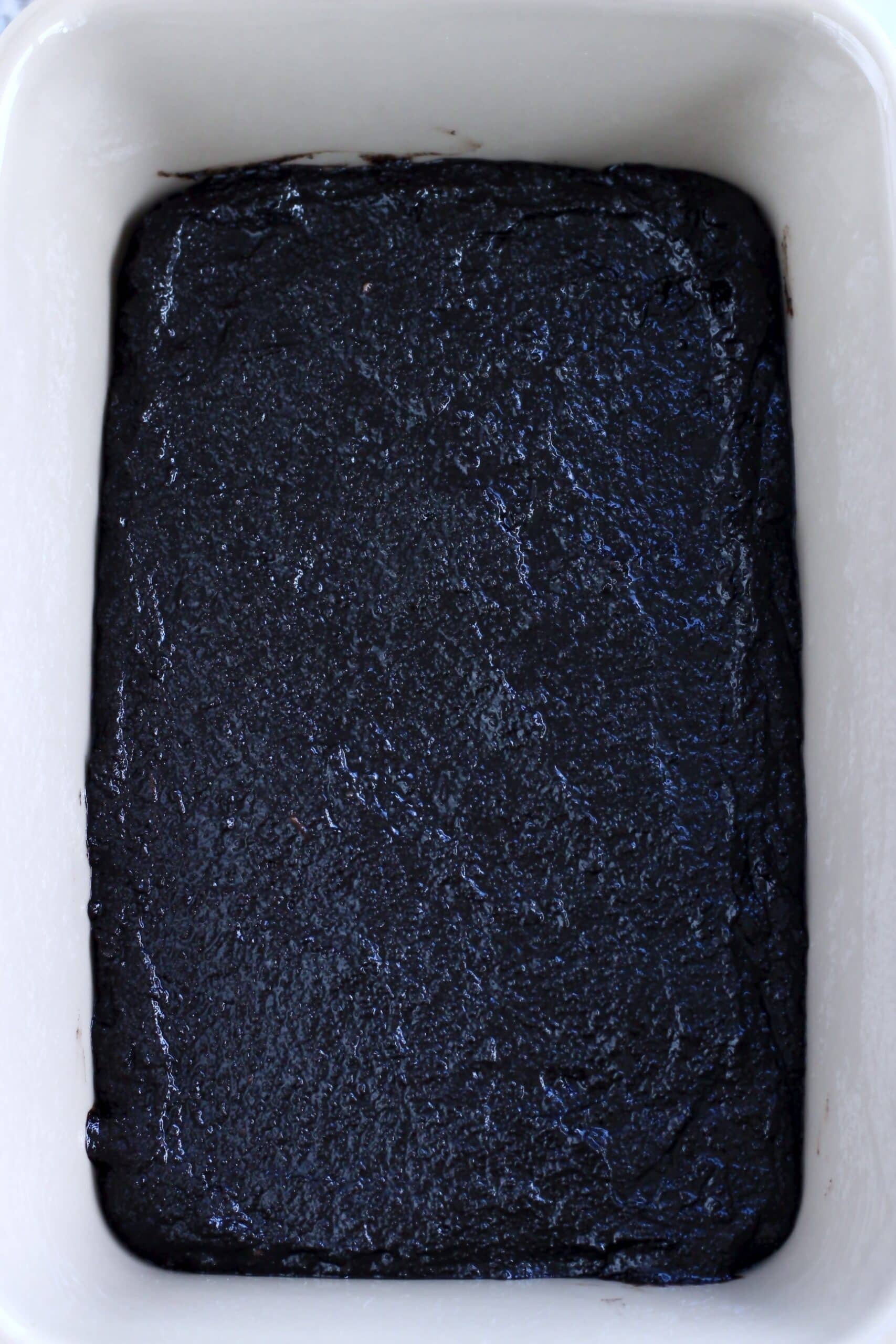 Raw vegan chocolate self-saucing pudding batter in a rectangular baking dish