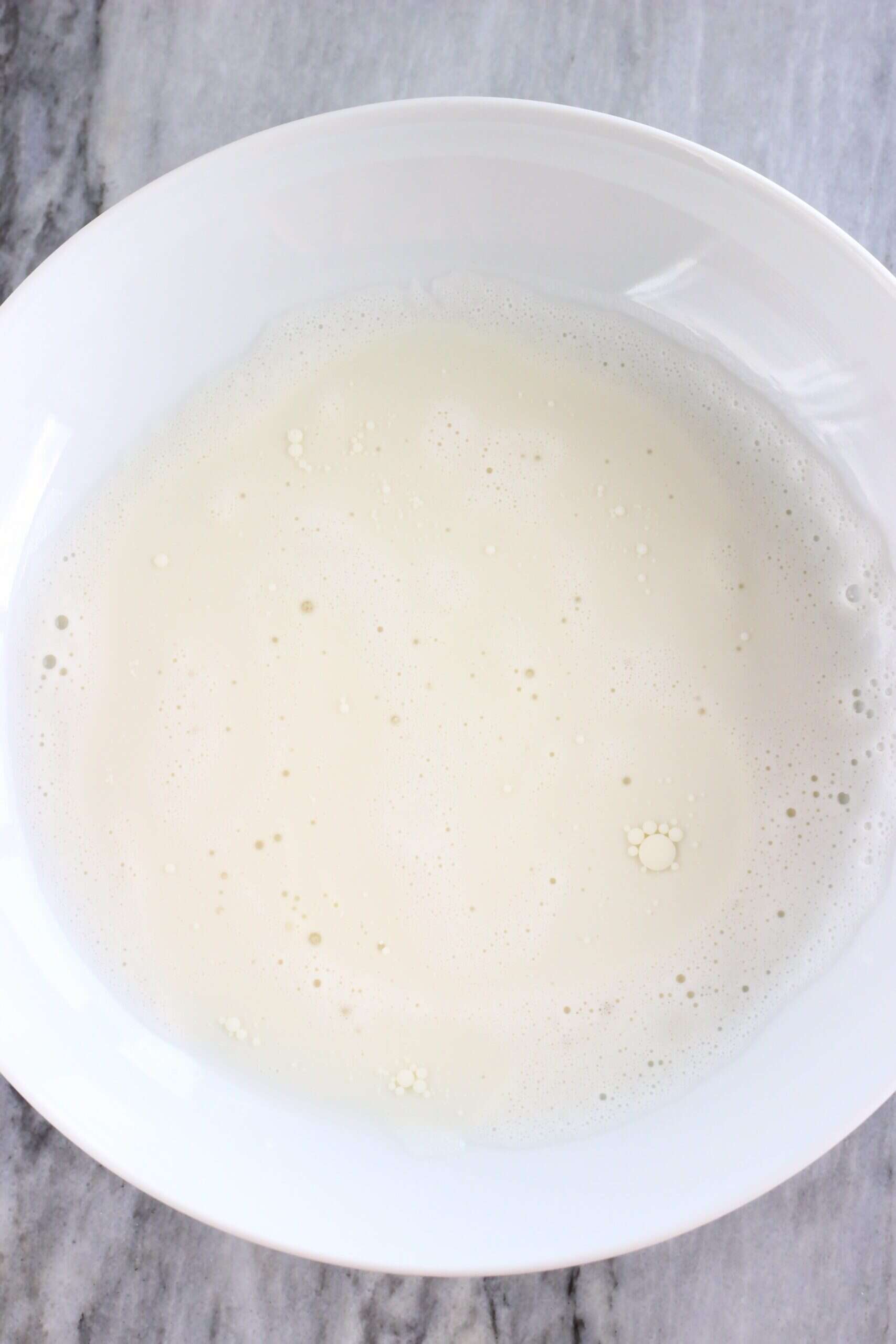 Almond milk and coconut oil in a white bowl