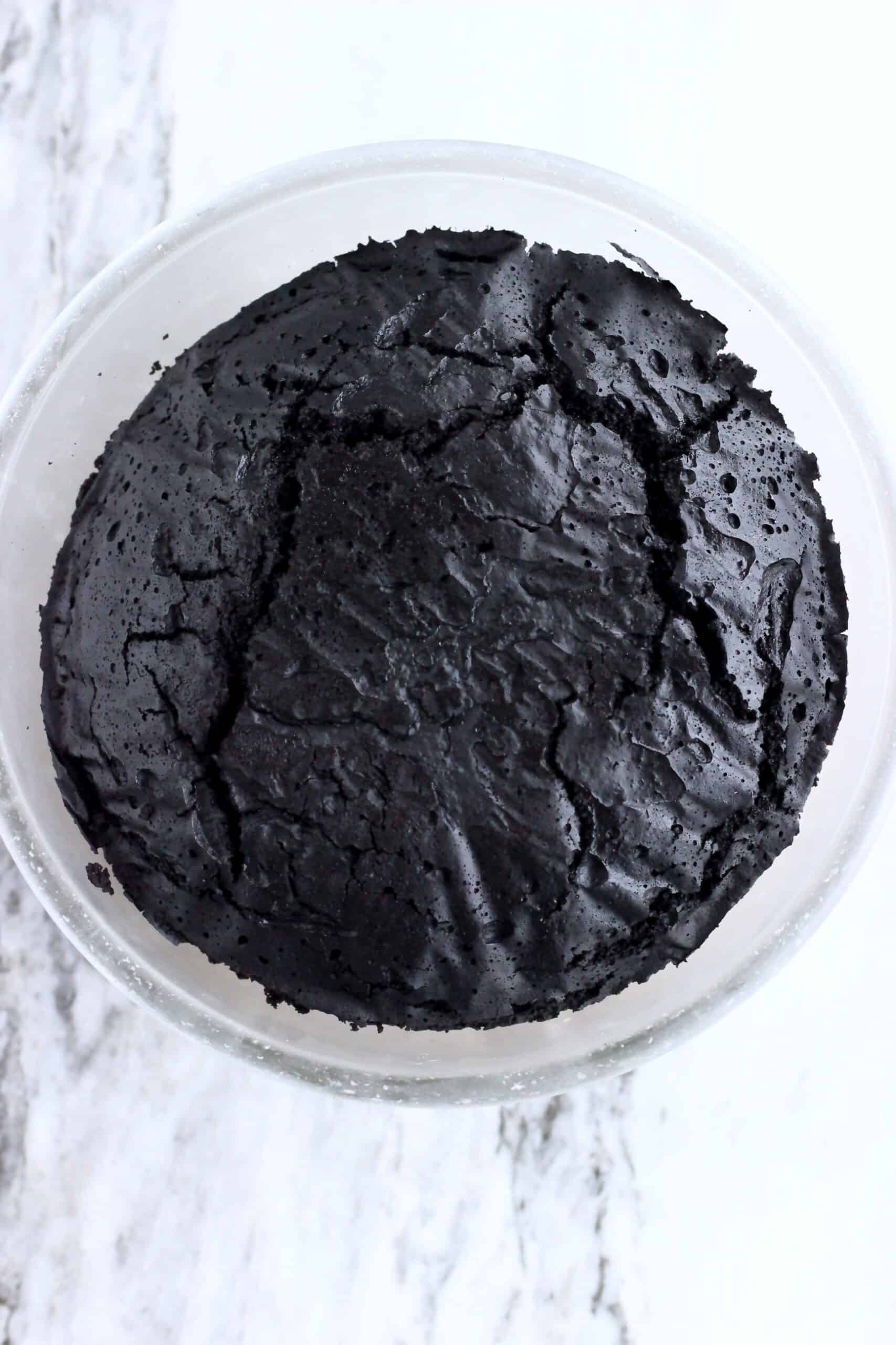 A cooked vegan chocolate Christmas pudding in a glass bowl