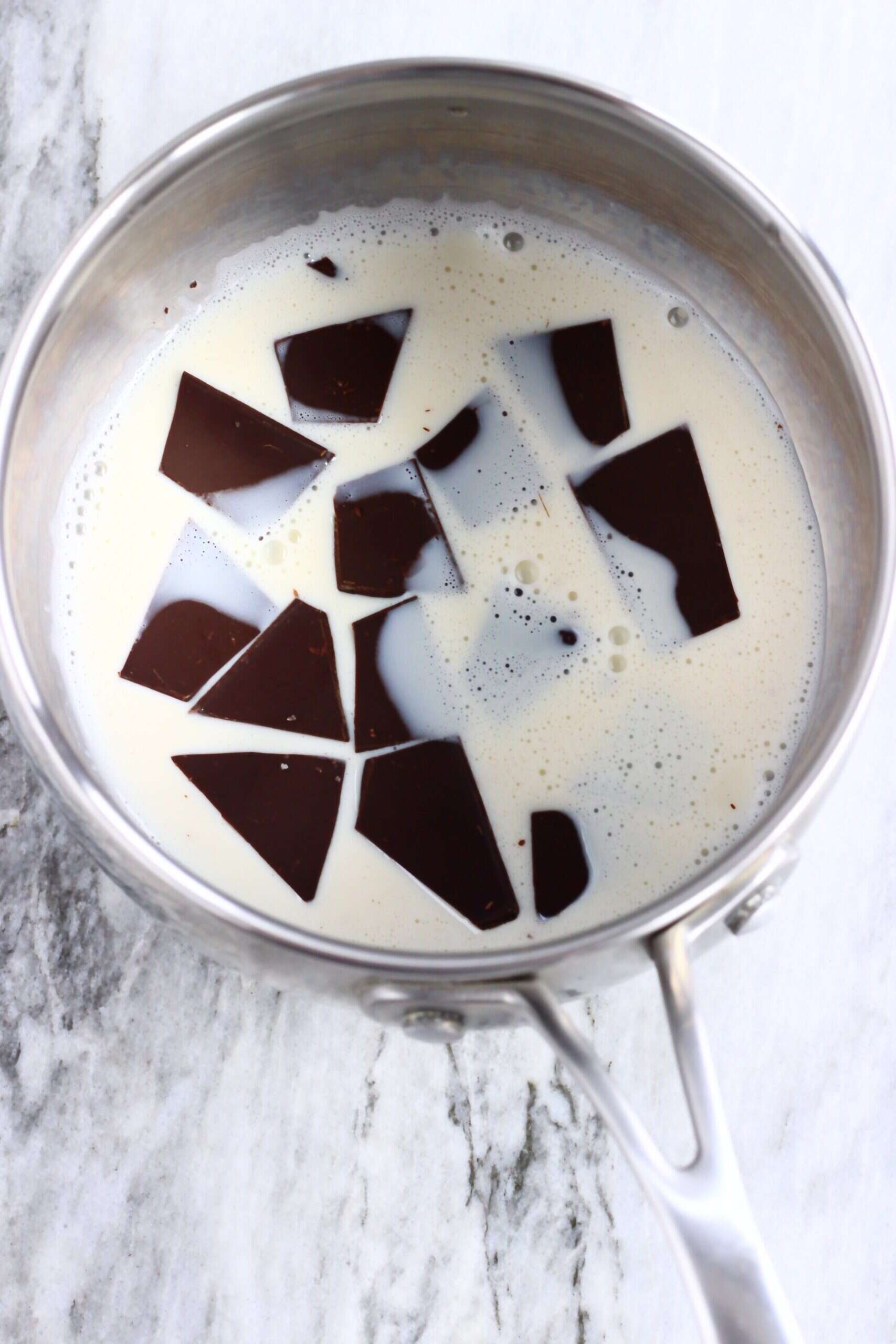 Dark chocolate pieces and almond milk in a saucepan