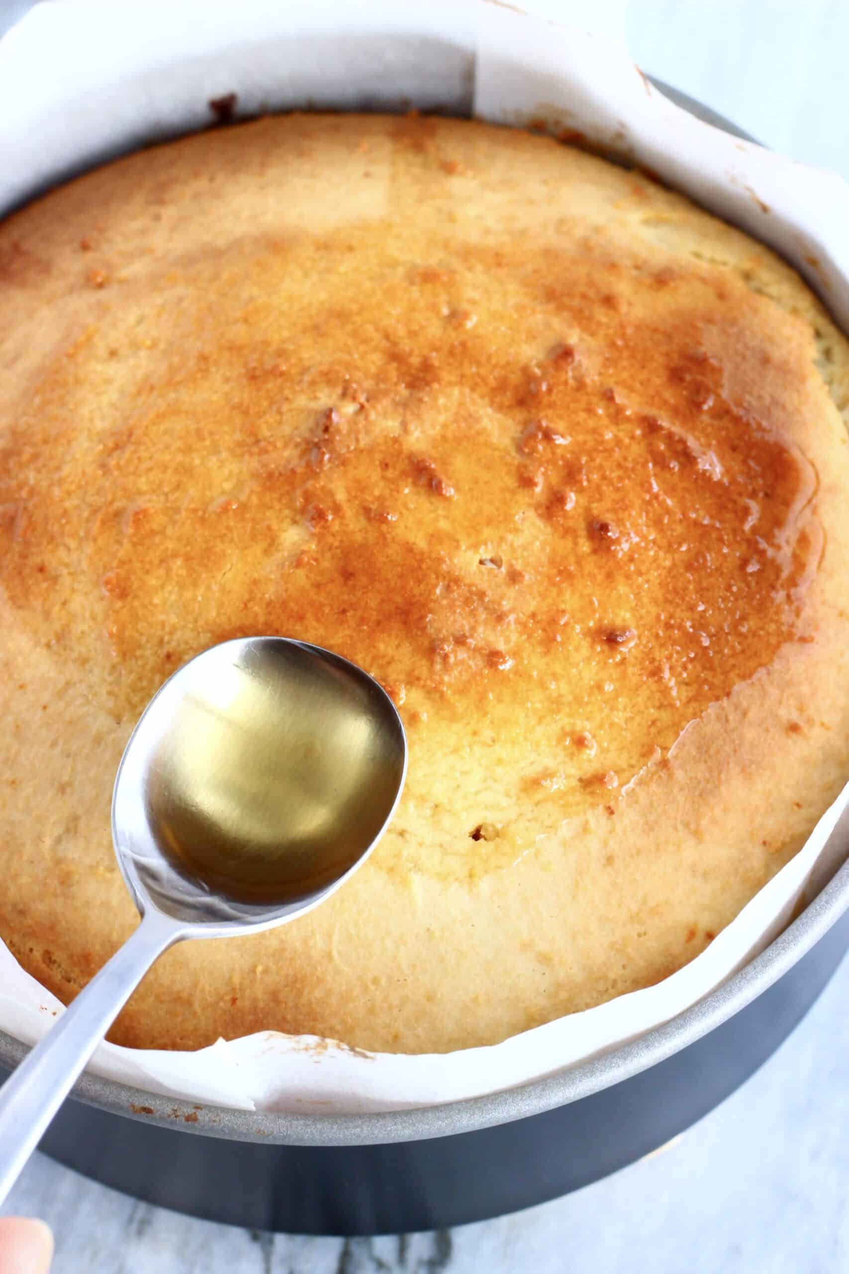 Honey syrup being drizzled over Vegan Honey Cake with a spoon