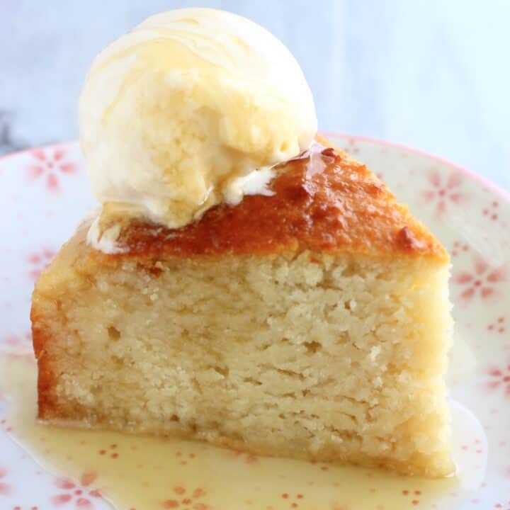 A slice of Vegan Honey Cake on a plate with a scoop of vanilla ice cream and honey syrup