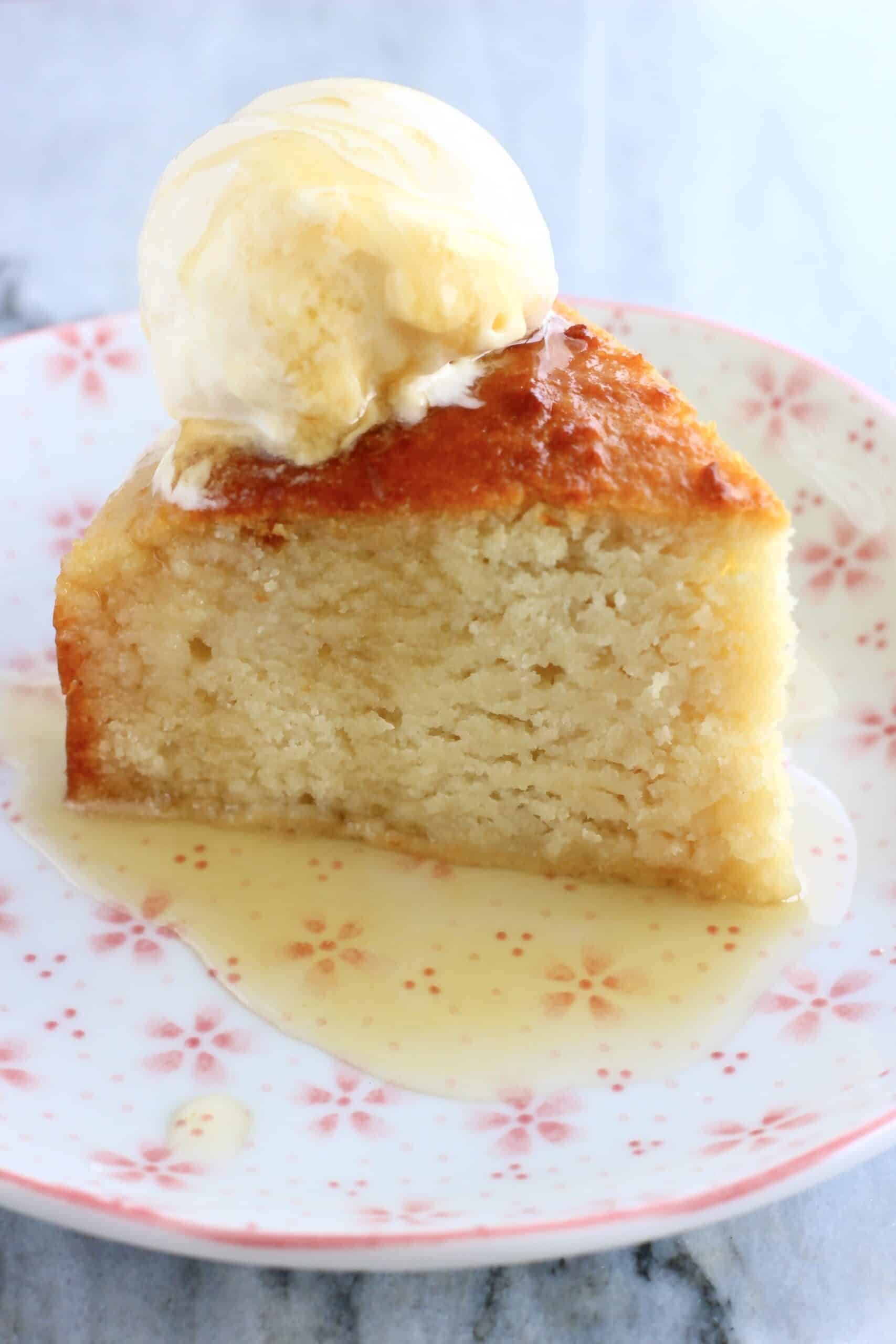A slice of Vegan Honey Cake on a plate with a scoop of vanilla ice cream and honey syrup