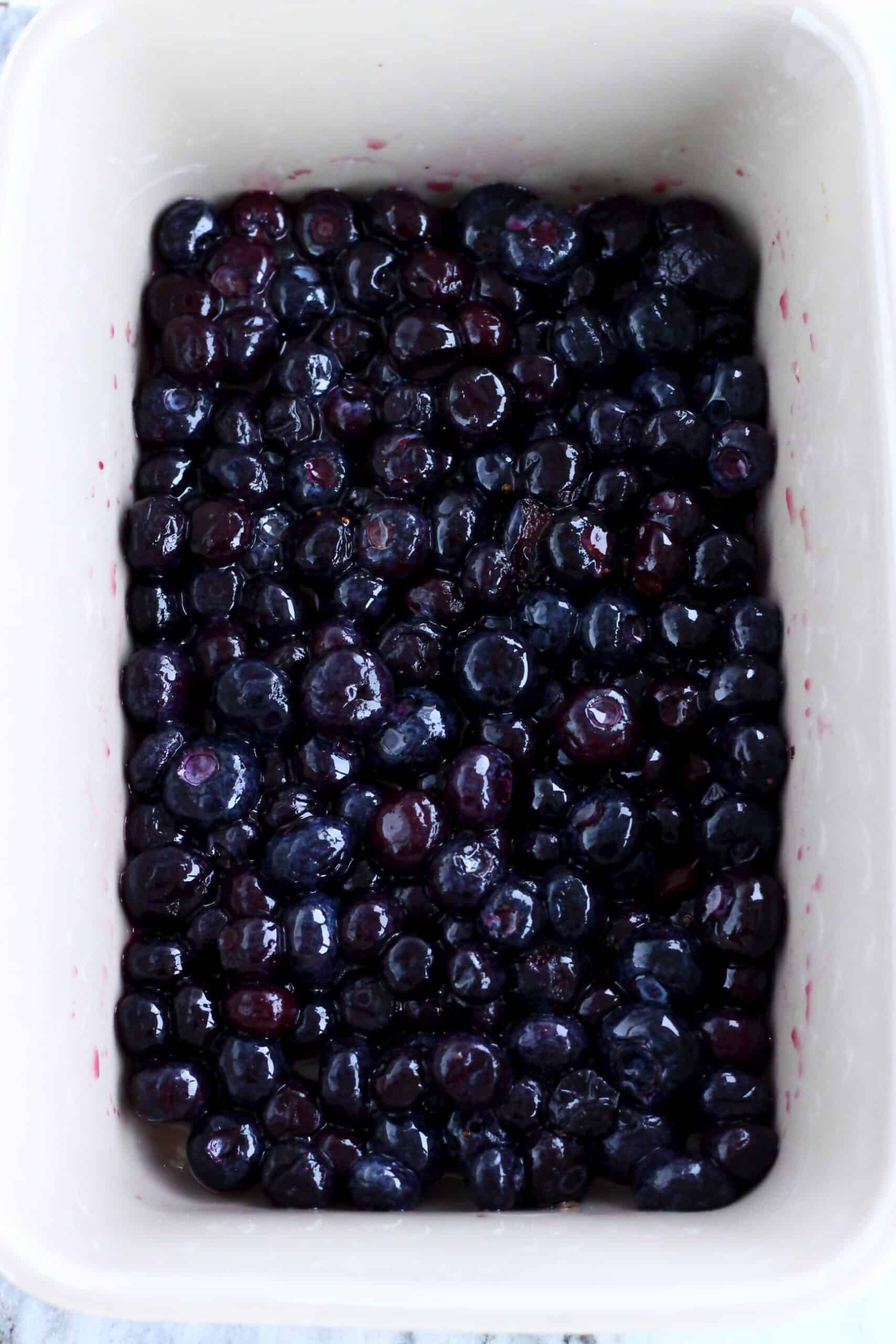 Fresh blueberries, maple syrup and lemon juice in a rectangular baking dish